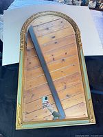 Front view of arch-top mirror showing frame and glass