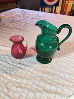 Both pitchers side by side on tablecloth