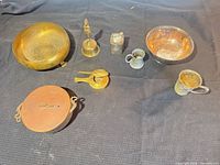 Group shot of all seven metalware items on black cloth