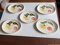 Top view of all five oval plates showing tulip design and scalloped rims