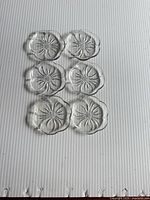Top view of six clear glass flower-shaped dishes arranged in two columns