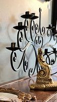 Black scrollwork cast iron five-cup candelabra on tabletop