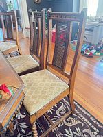 Three of the four vintage cane back dining chairs beside table