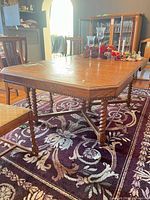 Full view of dining table on rug showing top surface and leg style