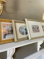 Three of the framed prints leaned on mantel