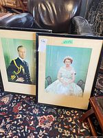 Both framed portraits on floor with black frames and mats visible
