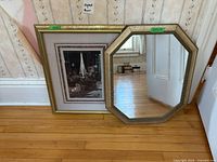 Front view of octagonal mirror and framed print leaning against wall