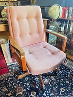 Full view of chair showing upholstery, wooden arms and base