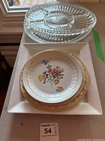 Group shot of all plates stacked showing glass divided dish, glass platter, porcelain plates and square tray