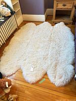 Full view of ivory sheepskin rug on floor