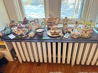 Wide view of entire collection on shelf – multiple novelty teapots, cups, figurines and ornaments visible