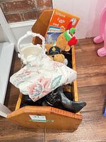 Overall view of wooden crib with toys, books, mask