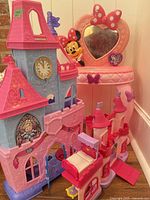 Overview of all three playsets: Little People castle, Minnie Mouse vanity, small red-turret castle