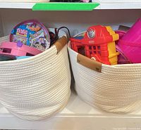 Two rope hampers filled with toys