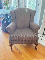 Front view of striped wingback armchair showing upholstery and overall form