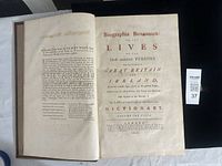 Open book displaying engraved title page with red and black text