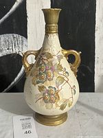Full front view of vase showing handles, floral decoration, height reference tag