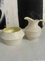 Creamer and sugar bowl side by side showing relief pattern and yellow interior