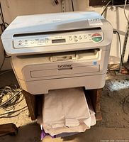 Front view of Brother DCP-7030 printer on wooden stand