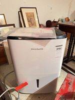 Front view of Frigidaire dehumidifier showing brand logo, model styling, and water level window