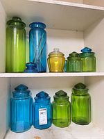 Entire collection of colored glass canisters and jars on two shelves