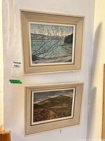 Both framed paintings hung on wall