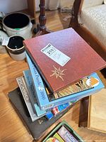 Stack showing travel Scrabble case and multiple puzzle boxes