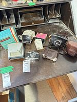 Desk surface showing all cameras, slide viewers, cases and boxes