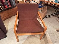 Front view of wood frame armchair with brown cushions