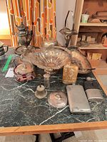 Group shot of all tableware pieces and hip flasks on marble surface