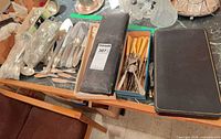 Assorted flatware, two cases on tabletop