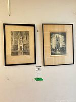 Both framed etchings side by side on wall