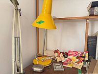 Overall lot showing yellow lamp, Schuco car, manuals, key and small metal pieces
