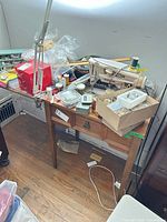 Full view of sewing machine on wooden cabinet with drawer