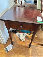 Front three-quarter view of side table showing drawer and turned legs