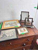 Overall lot showing two metal tabletop frames and four framed prints atop dresser