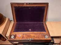 Desk open showing purple velvet writing surface, inkwell recesses and compartments