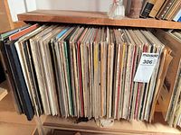 Full shelf row of vinyl LPs showing quantity and wear on jackets