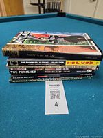 Stack of six graphic novels showing spines