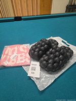 Bubble slide sandals and beanie in packaging on pool table