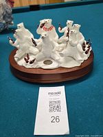 Front view of resin polar bear figurine group showing nine bears with Coca-Cola bottles