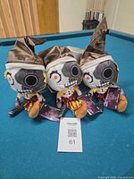 Three plush dolls on pool table