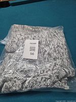 Factory-sealed bag containing marled knit hoodie