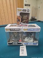 Group shot of all three boxed Funko Pop figures on pool table
