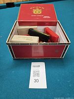Overview of Punch cigar box with harmonicas and case on pool table