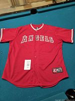 Full view of red Los Angeles Angels Majestic jersey laid flat