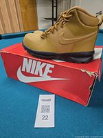 Side view of right boot on box showing Nike swoosh and overall style