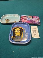 Overview of all three metal rolling trays with cartoon prints