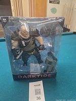 Front view of boxed Ogryn figure showing Warhammer Darktide branding and accessory