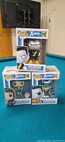 Front view of three boxed Funko Pop X-Men figures on table